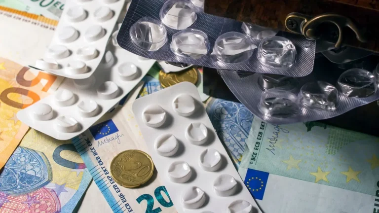 Blister packs of medication placed on Euro banknotes, illustrating healthcare expenses.