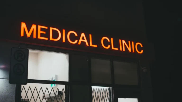 Bright neon medical clinic signage at night, creating a vivid street scene.