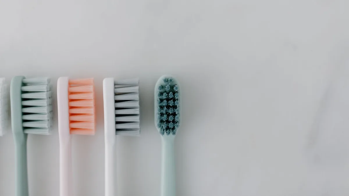 A close-up of neatly arranged toothbrushes on a marble background emphasizing dental care.