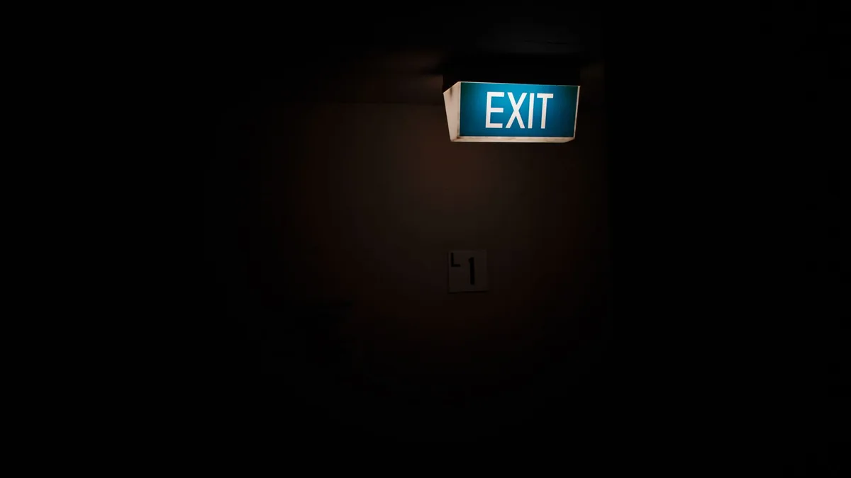 Dark interior space featuring a bright, illuminated exit sign for guidance.