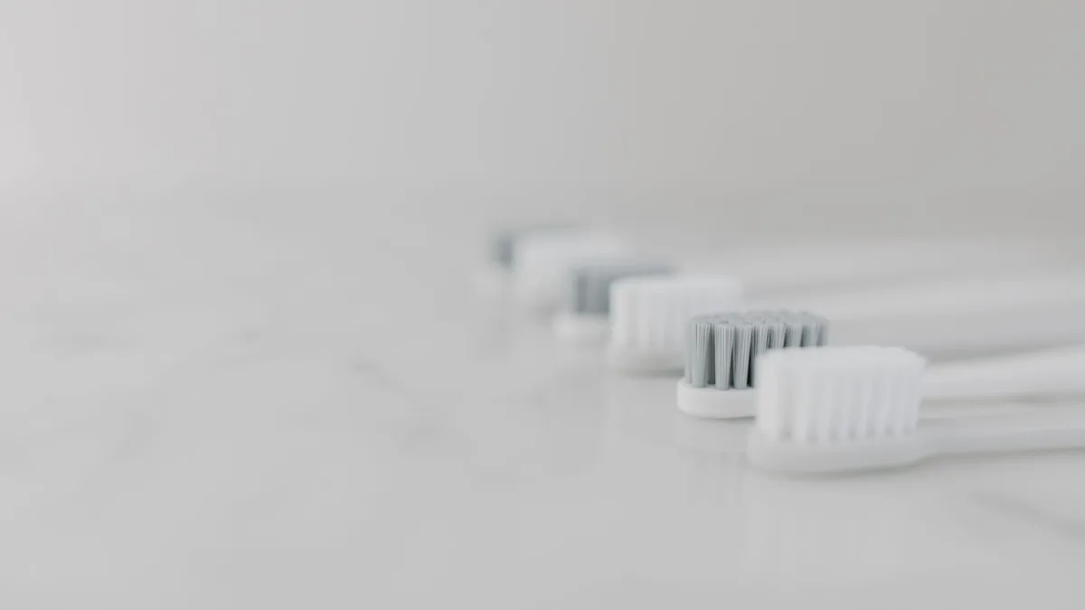 A modern and clean still life composition featuring multiple toothbrushes aligned on a marble surface with copy space.