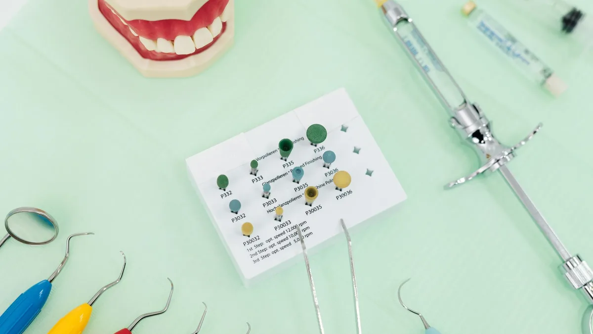 A close-up of dental tools and a jaw model on a green background, ideal for dentistry themes.